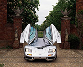 AUT 28 RK0024 06
McLaren F1 Silver Head On View With Doors Open In Front Of Gate On Stone Pavement