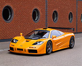 AUT 28 RK0056 07
1996 McLaren F1 LM Orange Front 3/4 View On Pavement By Brick Wall