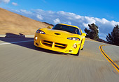 AUT 29 RK0479 04
1996 Hennessey Viper Venom 650R Yellow In Motion On Road Slanted 3/4 Front View Dry Grass Hill Blue Sky