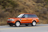 AUT 29 RK0859 01
2006 Range Rover Sport Supercharged Orange 3/4 Side View On Road In Motion