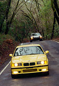 AUT 29 RK0019 07
1995 BMW M3 Yellow Head On View On Road In Motion By Trees