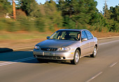 AUT 29 RK0216 05
1999 Chevrolet Malibu Champagne Front 3/4 View On Road In Motion By Trees Background