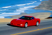 AUT 29 RK0273 19
1999 Chevrolet Corvette Red Side 3/4 View On Road In Motion By Beach