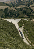 AUT 29 RK0800 01
Overhead Shot Of Six SUVs Descending Dirt Road Into Valley