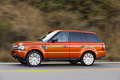 AUT 29 RK0860 01
2006 Range Rover Sport Supercharged Orange 3/4 Side View On Road In Motion