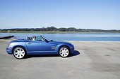 AUT 29 RK0955 01
2004 Chrysler Crossfire Convertible Blue Profile On Road In Motion By Lake