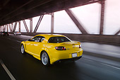 AUT 29 RK1160 01
2005 Mazda RX8 Yellow 3/4 Rear View On Road In Motion