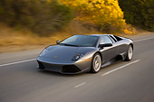 AUT 29 RK1196 01
2007 Lamborghini Murcielago LP640 Gray 3/4 Front View On Road In Motion By Trees