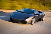 AUT 29 RK1199 01
2007 Lamborghini Murcielago LP640 Gray 3/4 Front View On Road In Motion By Trees