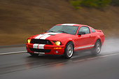 AUT 29 RK1255 01
2007 Ford Shelby Mustang GT500 Coupe Red And White 3/4 Front View On Road In Motion