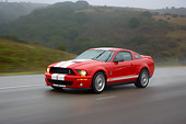 AUT 29 RK1263 01
2007 Ford Shelby Mustang GT500 Coupe Red And White 3/4 Side View On Road In Motion