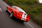 AUT 29 RK1269 01
2007 Ford Shelby Mustang GT500 Coupe Red And White 3/4 Rear View On Road In Motion