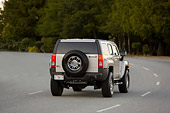 AUT 29 RK1365 01
2007 Hummer H3 Silver 3/4 Rear View On Road In Motion By Trees