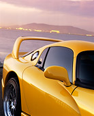 AUT 30 RK0429 02
1996 Hennessey Viper Venom 650R Yellow Side Rear View By Water Mountains Dark Clouds