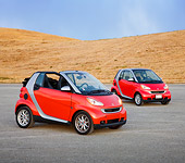 AUT 31 RK0103 01
2009 Smart Fortwo Passion Cabriolet And Coupe Red And Silver 3/4 Front View On Pavement By Hills