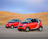 AUT 31 RK0104 01
2009 Smart Fortwo Passion Cabriolet And Coupe Red And Silver 3/4 Front View On Pavement By Hills