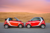AUT 31 RK0105 01
2009 Smart Fortwo Passion Cabriolet And Coupe Red And Silver Profile View On Pavement By Hills