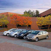 AUT 31 RK0100 01
Four 2006 Toyota Priuses 3/4 Front View On Pavement By Autumn Trees And Building