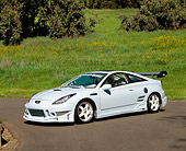 AUT 33 RK0285 02
2000 Toyota Celica Custom Sky Blue 3/4 Side View On Pavement By Grass Hill And Trees