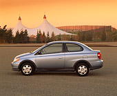 AUT 33 RK0090 02
2000 Toyota Echo Coupe Silver Profile View On Pavement White Tents Filtered