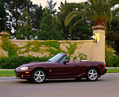 AUT 33 RK0163 02
2000 Mazda Miata Convertible Mahogany 3/4 Side View On Pavement By Wall