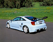 AUT 33 RK0293 01
2000 Toyota Celica Custom Sky Blue 3/4 Rear View On Pavement By Grass Hill And Trees