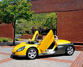 AUT 33 RK0344 03
2000 Renault Sport Spider Yellow Butterfly Door 3/4 Front View On Pavement By Brick Wall