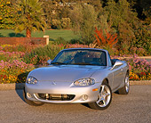 AUT 34 RK0155 01
2001 Mazda Miata Convertible Silver 3/4 Front View On Pavement By Flowers And Trees