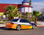 AUT 34 RK0360 02
2001 Chevrolet Cavalier Yellow And Silver 3/4 Rear View On Pavement By Building Pal Tree