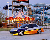 AUT 34 RK0361 01
2001 Chevrolet Cavalier Silver And Yellow Front 3/4 View On Pavement By Amusement Park