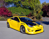 AUT 35 RK0375 03
2002 Toyota Celica GTS Custom Yellow And Black 3/4 Front View On Pavement By Bushes