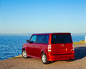 AUT 39 RK0198 02
2004 Toyota Scion XB Orange Rear 3/4 View On Pavement By Water Blue Sky