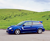 AUT 39 RK0337 03
2004 Ford Saleen N20 Focus Blue 3/4 Side View On Pavement By Grass Hills