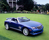 AUT 40 RK0053 01
2005 Chrysler Crossfire SRT-6 Convertible Blue 3/4 Front View On Grass By Building