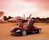 AUT 40 RK0065 03
2005 Spyker C8 Spyder Black 3/4 Front View Doors Open On Pavement By Fighter Jet