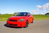 AUT 40 RK0159 01
2005 Scion TC Red 3/4 Front View On Pavement By Grass