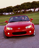 AUT 41 RK0049 03
2006 Mazda, MX5, Miata, Convertible, Red Head On Shot With Driver On Pavement By Golf Course