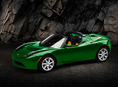 AUT 43 RK0414 01
2008 Tesla Roadster Hybrid Green 3/4 Side View On Pavement By Rock Wall