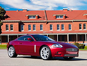 AUT 43 RK0114 01
2008 Jaguar XKR Coupe Red 3/4 Front View On Pavement By Building