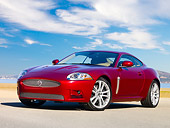 AUT 43 RK0115 01
2008 Jaguar XKR Coupe Red 3/4 Front View On Pavement By Water Blue Sky