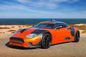 AUT 44 RK0129 01
2009 Spyker C8 Laviolette LM85 Orange And Black 3/4 Front View On Sand By Ocean