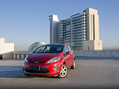 AUT 46 BK0023 01
2011 Ford Fiesta Red 3/4 Front View On Pavement By Buildings