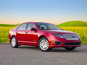 AUT 46 BK0044 01
2011 Ford Fusion Hybrid Red 3/4 Front View On Pavement By Field Of Wildflowers