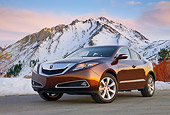 AUT 46 BK0054 01
2011 Acura ZDX Burnt Orange 3/4 Front View On Pavement By Snowy Mountains