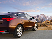 AUT 46 BK0056 01
2011 Acura ZDX Burnt Orange 3/4 Rear View On Pavement By Snowy Mountains