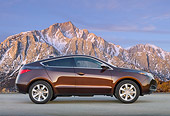 AUT 46 BK0057 01
2011 Acura ZDX Burnt Orange Profile View On Pavement By Snowy Mountains