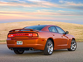 AUT 46 RK0059 01
2011 Dodge Charger RT Orange 3/4 Rear View On Pavement By Dry Grassy Hill