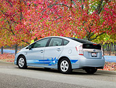AUT 48 RK0022 01
2012 Toyota Prius Plug-In Hybrid Blue 3/4 Rear View On Pavement By Autumn Trees
