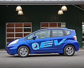 AUT 48 RK0062 01
2012 Honda Fit EV Blue Profile View On Pavement By Building