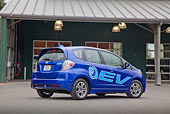 AUT 48 RK0065 01
2012 Honda Fit EV Blue 3/4 Rear View On Pavement By Building